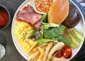 Traditional British all day breakfast dish, sausage, bacon, mushroom, tomato, bread, egg, fries and vegetable Royalty Free Stock Photo