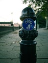 Traditional British black bollard with road signs at a sidewalk