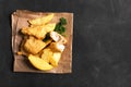 Traditional British fish and chips on the dark surface