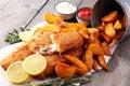 Traditional British fish and chips with potato and lemon.