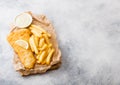 Traditional British Fish and Chips with tartar sauce on chopping board and lemon slice on white stone table background. Space for Royalty Free Stock Photo