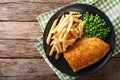 Traditional British food: Fish and chips with green peas close-up on a plate. Horizontal top view Royalty Free Stock Photo