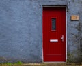 Traditional English house facade front entrance with red closed door . Royalty Free Stock Photo