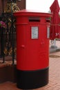 Traditional british red post box on street. Royalty Free Stock Photo