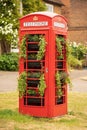 Traditional British red public telephone box filled with plants. Hertfordshire. UK