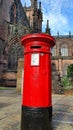 A traditional, British, red, Royal Mail post box with a backdrop of Chester cathedral Royalty Free Stock Photo