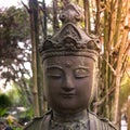 Traditional buddhist statue of female in bamboo garden