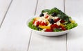 Traditional Bulgarian dish, Shopsky salad, with vegetables and cheese, on a white background, no people, horizontal,