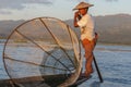 Traditional Burmese fishermen with fishing net at Inle lake in Myanmar famous for their distinctive one legged rowing style, Royalty Free Stock Photo