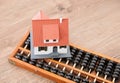 A traditional calculation tool abacus and a small house model on the table Royalty Free Stock Photo