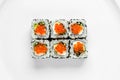 Traditional california sushi roll with red caviar, cucumber on a white background top view