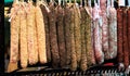 Traditional Catalan sausage `Fuet` in spices, various types of sausages in the farmers market