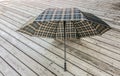 Traditional checkered umbrella on a wooden deck outside