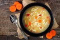 Traditional chicken noodle soup, overhead scene on rustic wood