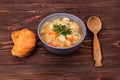 Traditional chicken soup with noodles, vegetables and parsley leaves served with two slices of baked bread on a rustic wood Royalty Free Stock Photo