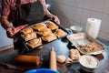 Traditional Chilean Cuisine: Unrecognizable Latina Woman Holding a Tray of Chilean Baked Empanadas in Her Rustic Kitchen