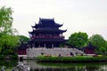 A traditional Chinese building built in modern times, with a large three-story attic, blue tiles and red columns, wooden structure