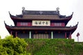 A traditional Chinese building built in modern times, the roof is carved with dragons, hung with lanterns, and a plaque written in