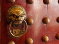 Traditional Chinese doors with brass handles symbolic of lion's heads