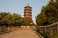 Traditional Chinese pagoda in sunlight with purple flowers Royalty Free Stock Photo