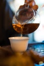 Traditional Chinese Tea Ceremony. Black or Red Tea pouring into White pial cup on dark Table background Royalty Free Stock Photo