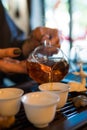 Traditional Chinese Tea Ceremony. Black or Red Tea pouring into White pial cup on dark Table background Royalty Free Stock Photo