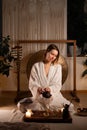 Traditional Chinese tea ceremony. Young woman pouring green tea into glass cups while sitting on the floor Royalty Free Stock Photo