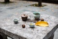 Traditional Chinese tea cups and jugs on a stone table in a park.