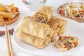 Traditional Chinese tortillas filled - bings in a plate on a white background, salads, Dam Sam snacks and cup