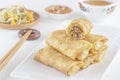 Traditional Chinese tortillas filled - bings in a plate on a white background, salads, Dam Sam snacks and cup of tea.