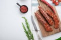 Traditional chorizo cuts with spices and ingredients on white textured background, topview with space for text