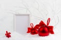 Traditional christmas background with blank photo frame mockup and rich sparkle red glossy balls with satin ribbons, bows in white Royalty Free Stock Photo