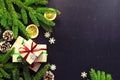 Traditional Christmas dark background top view. New Year composition Spruce branch Pine cone Presents Orange Snowflakes