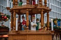 Traditional Christmas decoration. Details of wooden Christmas carousel with nativity scene and wood sculptural Christmas character Royalty Free Stock Photo