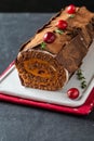 Buche de Noel. Traditional Christmas dessert, Christmas yule log cake with chocolate cream, cranberry. On stone gray Royalty Free Stock Photo