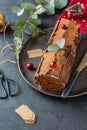 Buche de Noel. Traditional Christmas dessert, Christmas yule log cake with chocolate cream, cranberry. Copy space. Royalty Free Stock Photo