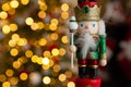 Christmas nutcracker wooden figure, toy soldier decoration with tree lights bokeh. Royalty Free Stock Photo