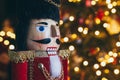 Christmas nutcracker wooden figure, toy soldier decoration with tree lights bokeh.