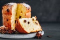 Traditional Christmas Panettone cake with dried fruits on dark stone background