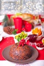 Traditional Christmas pudding with holly on top. Royalty Free Stock Photo