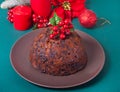 Traditional Christmas pudding with holly on top and Christmas decoration on the background Royalty Free Stock Photo