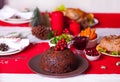 Traditional Christmas pudding with holly on top on a Christmas dinner Royalty Free Stock Photo