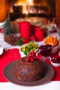 Traditional Christmas pudding with holly on top on a Christmas dinner. Royalty Free Stock Photo