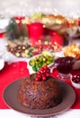 Traditional Christmas pudding with holly on top on a Christmas dinner. Royalty Free Stock Photo