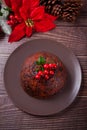 Traditional Christmas pudding with holly on top on the wooden background Royalty Free Stock Photo