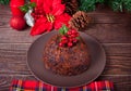 Traditional Christmas pudding with holly on top on the wooden background Royalty Free Stock Photo