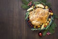 Traditional Christmas roasted chicken with potatoes and rosemary on wooden table. Top view.