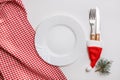 Traditional Christmas table place setting with empty white plate, linen napkin, cutlery with festive decorations Royalty Free Stock Photo