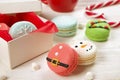 Traditional christmas themed french macaroons sweets in the form of snowman, snowflake, christmas tree and santa`s belly with can