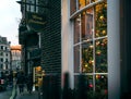 Traditional Christmas Tree in Cosy Room behind Window with British Street Scene at Sunset, London, UK